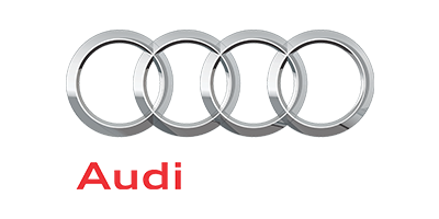 Close-up of Audi logo with four interlinked silver rings and partial red text.